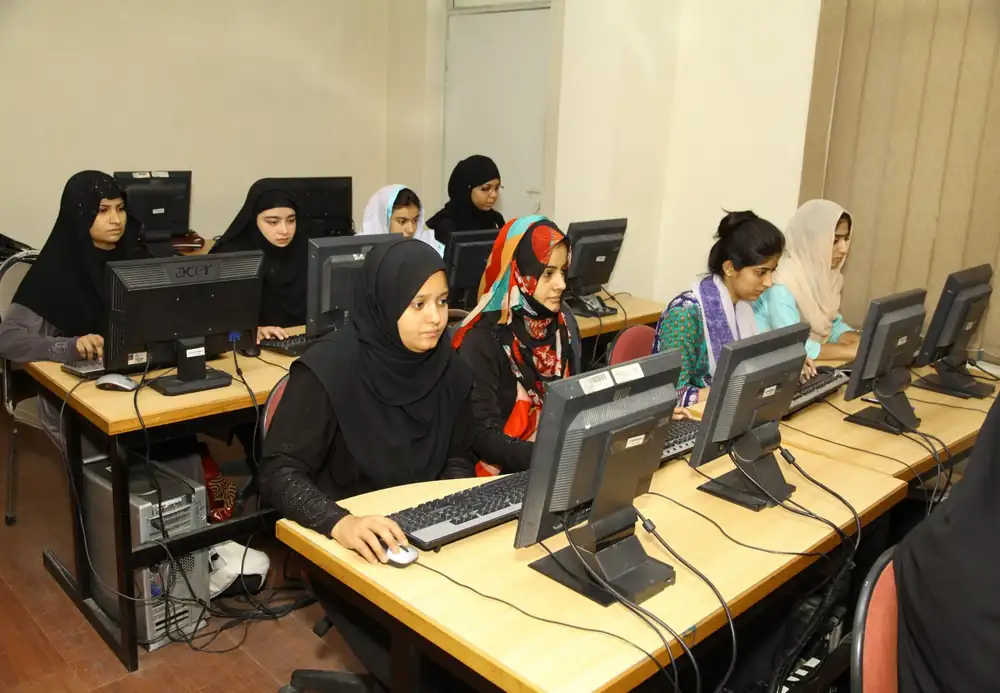 Young women learning digital skills at computers in a training lab
