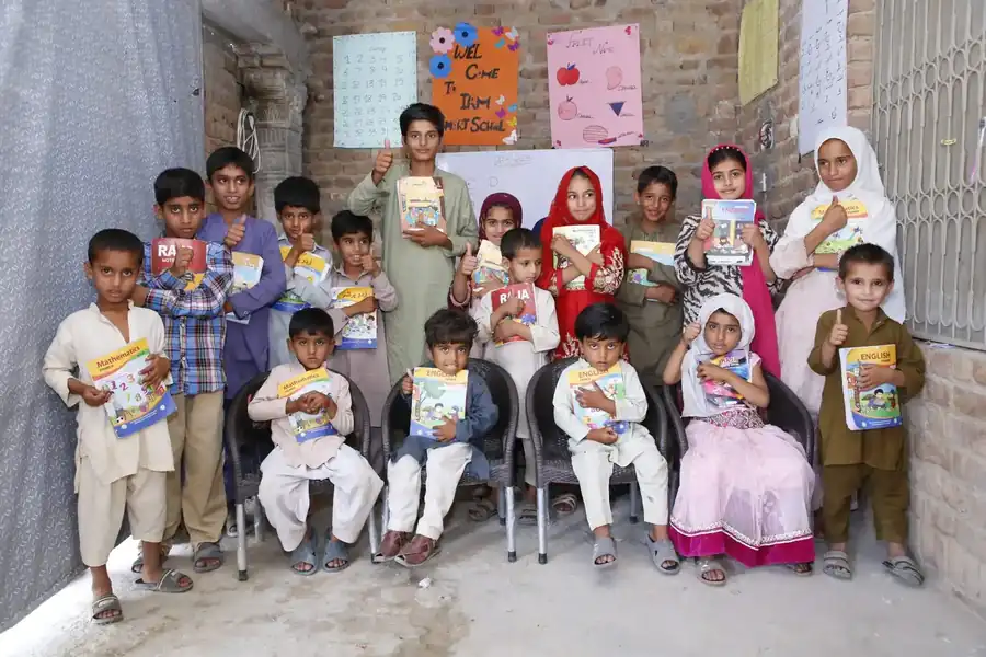 Smart School pupils holding their books, standing with their women teachers outside the classroom
